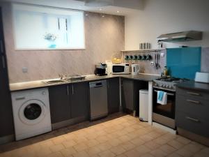a kitchen with a sink and a washing machine at Maison Raffinee in Treignac