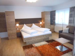 ein Wohnzimmer mit einem Bett und einem Sofa in der Unterkunft Appartements Garni Alpin Live in Samnaun