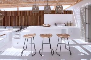uma cozinha com um balcão e dois bancos em Phos Home by Rocks Estates em Naousa