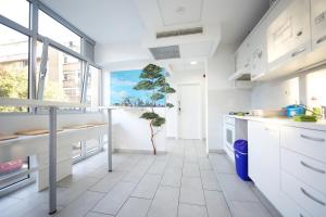 a kitchen with white cabinets and a large window at Funk Lounge Hostel in Zagreb