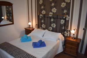 a bedroom with a bed with two blue slippers on it at La Villa del Lago in Iznájar +32 photos