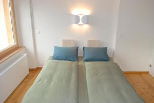 two beds sitting in a room with a window at Ferienwohnung Troegligasse in Andermatt