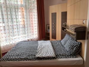 コマーロムにあるIdyllApartmanのベッドルーム1室(ベッド1台、白黒の枕付)