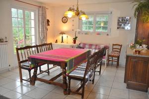 una sala da pranzo con tavolo e sedie in cucina di Chambres d'hotes Chez Annie a Brélès