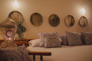 a bedroom with a bed with pillows and plates on the wall at Casa 5 Bed & Breakfast in Palenque