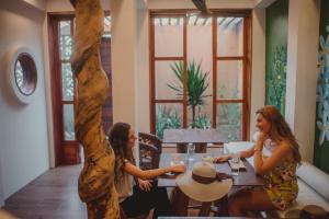 Due donne sedute a un tavolo in un ristorante di Casa 5 Bed & Breakfast a Palenque