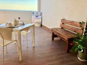 a table and bench in a room with a table and a bench at Charm Airport in Reggio di Calabria