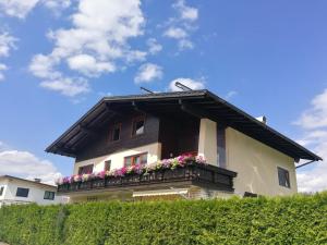 ein Haus mit einem Balkon mit Blumen darauf in der Unterkunft Wei Wei's Hostel in Ehenbichl