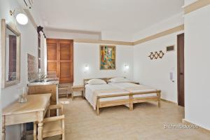 a bedroom with a bed and a sink in it at Philoxenia Studios 3 in Karpathos Town