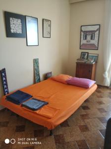 einen Tisch mit einem orangenen Bett in einem Zimmer in der Unterkunft Christo in Athen