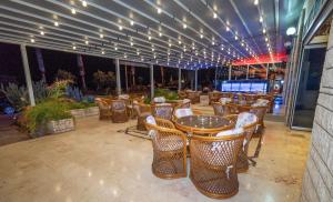 a restaurant with tables and chairs on a patio at Kleopatra Celine Hotel in Alanya