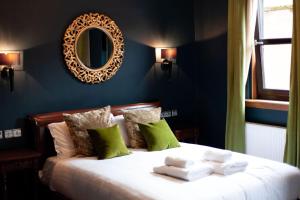 um quarto com uma cama com um espelho na parede em Friars Wynd Hotel em Stirling