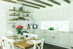 a white kitchen with a wooden table and white cabinets at The Peaceful Vacation in Muratsi