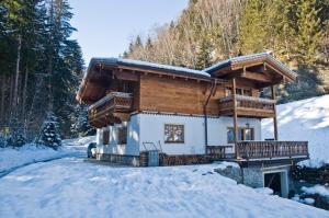 ein Blockhaus im Schnee im Wald in der Unterkunft Ferienwohnung Steiner in Wald im Pinzgau