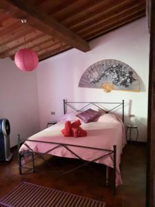 um quarto com uma cama com um cobertor rosa em Le Casette em Guardistallo