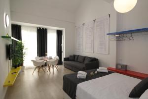 a bedroom with a bed and a couch and a table at Apartamentos Romero Luna in Málaga