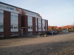 ein großes Backsteingebäude mit davor geparkt in der Unterkunft Nordstern in Cuxhaven