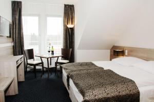 um quarto de hotel com uma cama e uma mesa com cadeiras em Pokoje gościnne WiP em Cieszyn