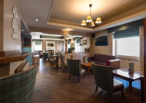 a restaurant with a bar and tables and chairs at The Swan Hotel in Clitheroe