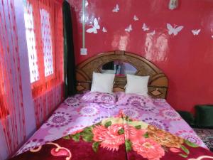 - une chambre avec un lit doté d'un couvre-lit rose dans l'établissement Homestay Hari Parbat, à Srinagar