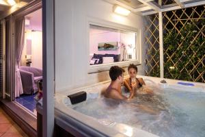 a man and a woman are bathing in a tub at Grifo Hotel Charme & SPA in Ischia