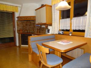 Una cocina con una mesa de madera y una mesa y sillas. en Ferienwohnung Frenner, en Sankt Martin bei Lofer