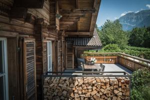 a deck with a table and chairs on a house at Hotel-Restaurant Burgseeli in Goldswil