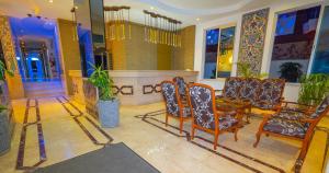 a lobby with chairs and a table in a building at Kleopatra Celine Hotel in Alanya