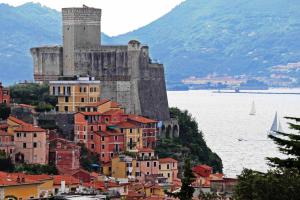 a town with a castle on top of a mountain at Hotel Della Baia in Portovenere