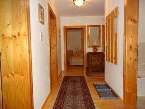 Un pasillo que conduce a una sala de estar con paneles de madera. en Ferienwohnung Frenner, en Sankt Martin bei Lofer