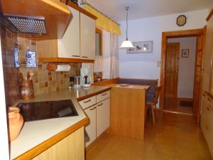 Una cocina con gabinetes de madera y encimera. en Ferienwohnung Frenner, en Sankt Martin bei Lofer 8 fotos más