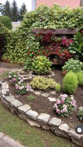 a garden with flowers and a stone path at Guesthouse Pavličić in Drežnik Grad