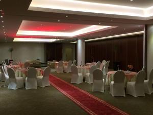 un salón de banquetes con mesas blancas y sillas blancas en Executives Hotel - Azizia, en Riad