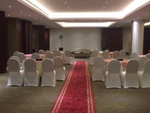 einen Konferenzraum mit weißen Stühlen und einem roten Teppich in der Unterkunft Executives Hotel - Azizia in Riad