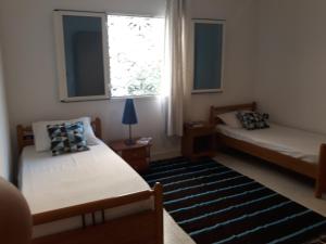 sypialnia z 2 łóżkami, oknem i dywanem w obiekcie Villa Bougainvillier w Susie