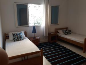 a bedroom with two beds and a window and a rug at Villa Bougainvillier in Sousse