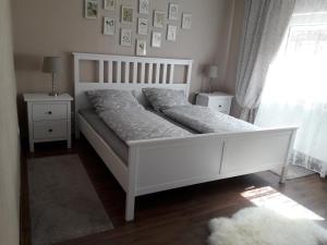 a white bed in a room with two night stands at Ferienwohnung Philipps in Kitzingen