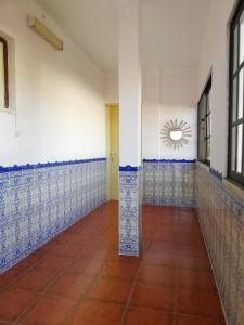 an empty room with blue and white tile walls at Casa Conceição in Atalaia