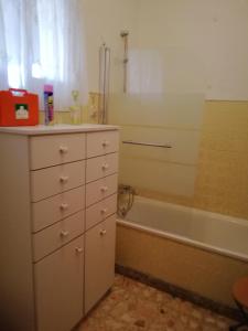 Casa Conceição في Atalaia: حمام مزود بخزانة ملابس بيضاء وحوض استحمام