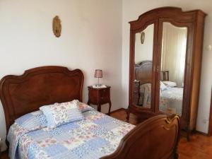 1 dormitorio con cama y espejo grande en Casa Conceição, en Atalaia