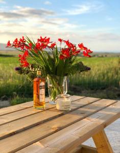 a vase of red flowers sitting on a wooden table at Atlantic View Apartments in Limavady