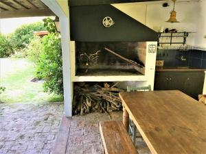 eine Küche mit einem Holztisch und einem Kamin in der Unterkunft Lo de Lanny in Colonia del Sacramento