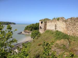 an old castle on a hill next to a body of water at Ma maison in Créhen +2 photos