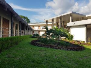 a courtyard of a building with grass and plants at Gran Hotel de Lago - Shushufindi in Shushufindi