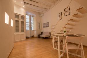 a living room with a staircase and a table and chairs at Loft Lamarmora 18 in Cagliari