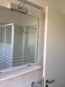a mirror in a bathroom with a shower and a sink at Case Vacanze Panarea by CivicoVentiquattro in Cava dʼAliga