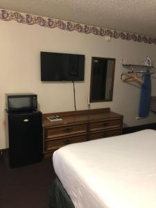 Habitación de hotel con cama y TV de pantalla plana. en Rexdale Inn, en Seminole