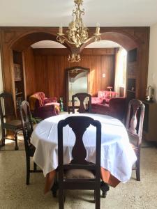 a dining room with a table and a chandelier at Del Parque in San Salvador de Jujuy