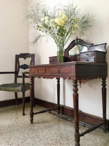 a vase of flowers sitting on a table with a chair at Del Parque in San Salvador de Jujuy