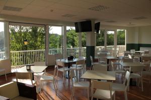 a restaurant with tables and chairs and windows at Rivera Del Tirón Apartamentos in Cuzcurrita-Río Tirón